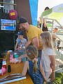 Ein Herr und 3 Kinder beim Ausprobieren einer Station